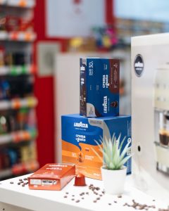 Pakiranja originalnih Lavazza kapsula Crema e Gusto i Qualità Rossa iz Italije, uz rasuta zrna kave.