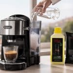 DeLonghi aparat za kavu na stolu, uz bočicu tekućine za čišćenje kamenca i filter, dok ruka ulijeva vodu u spremnik.