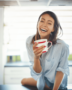 Žena koja je sretna dok ispija kavu iz šalice